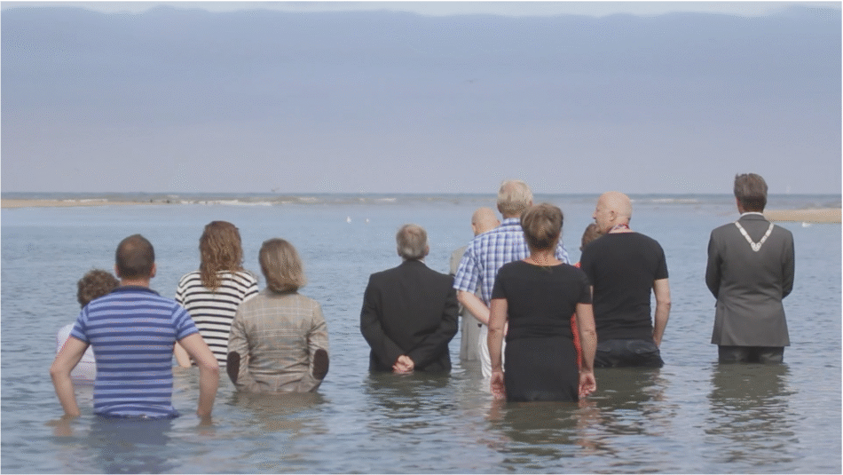People standing in shallow water. climate-performance-art-choreographies-of-collapse